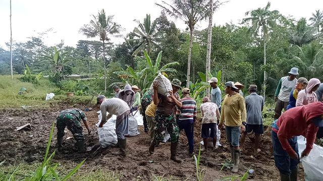 Babinsa Koramil 07Kalikajar bersama warga sekitar melakukan pembangunan tanggul selokan di Dusun Bakulan Kecamatan Kalikajar