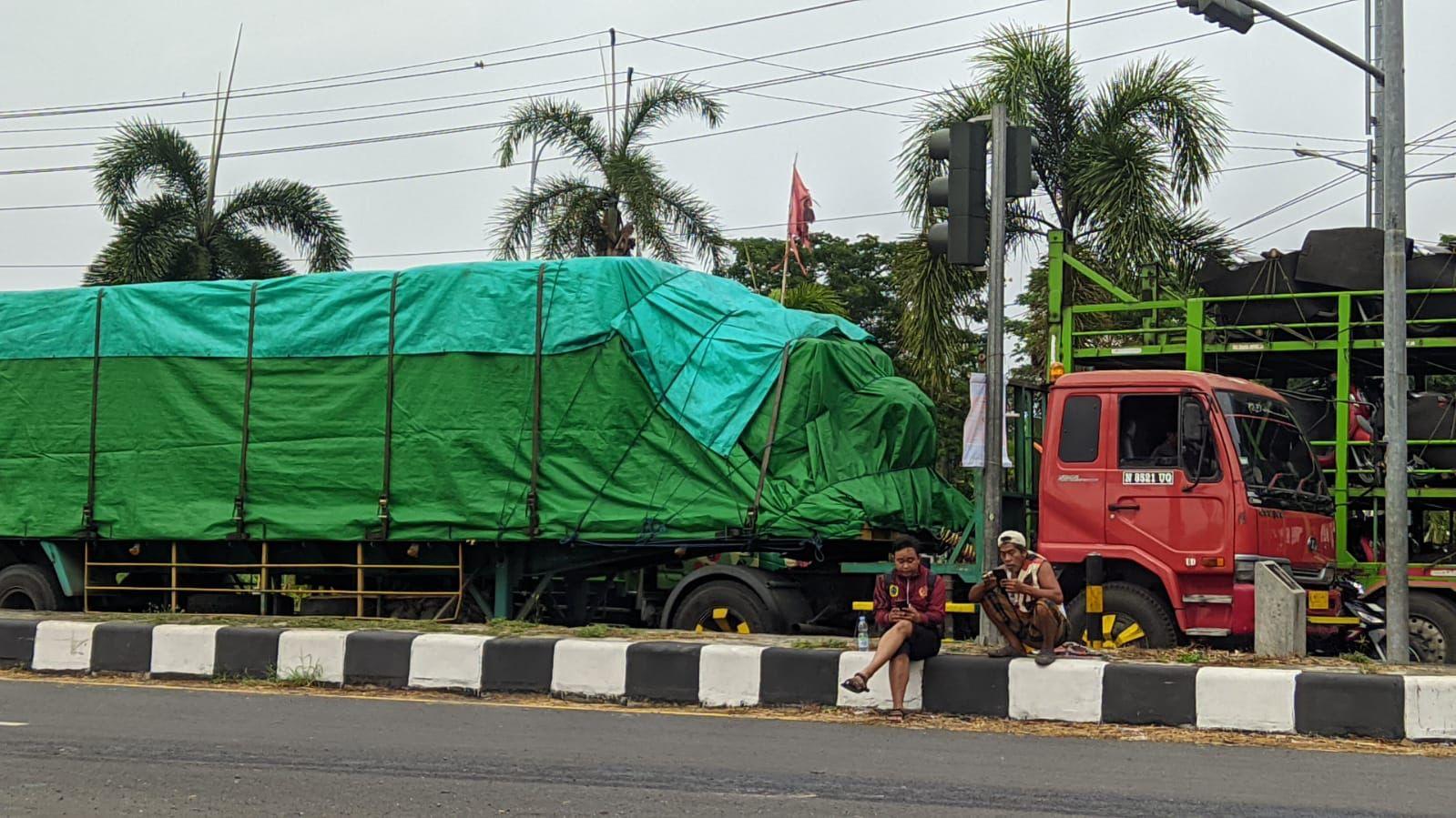 Sopir truk pengangkut barang terlihat bersantai di bahu jalan Lingkar Selatan (JLS) karena jenuh menunggu macet.