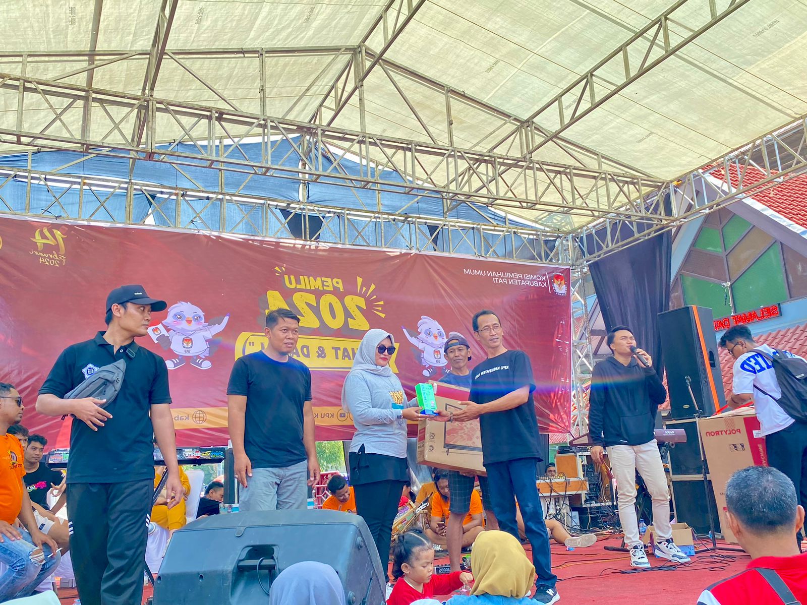 Ketua Devisi Hukum dan Pengawas KPU Pati, Haryono saat memberikan doorprize dalam acara Pemilu 2024 sehat dan damai di halaman Stadion Joyokusumo pada, Sabtu (23/12/23).