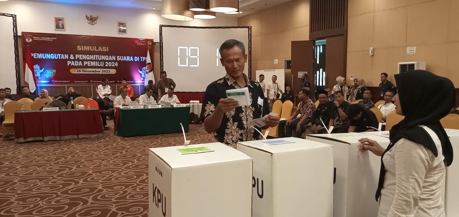 Petugas KPPS memberikan pengarahan kepada warga yang akan memasukkan surat suara setelah pencoblosan di bilik suara dalam simulasi yang digelar KPUD Karanganyar.