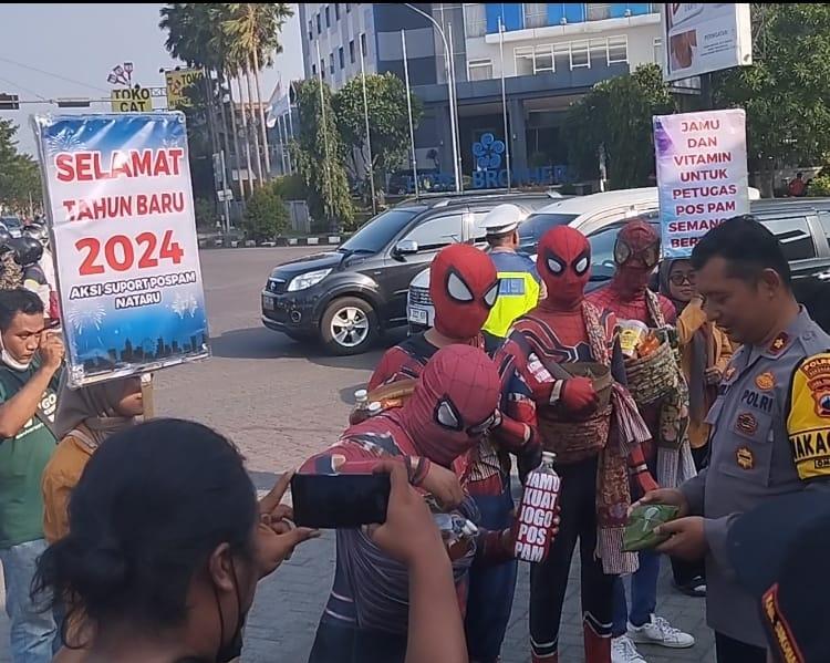 Sejumlah Superhero dan mahasiswa Universitas Veteran Bangun Nusantara (Univet) Sukoharjo membagikan Jamu gendong kepada petugas Pos Pam Natal dan Tahun Baru di Pospam Patung Pandawa Solobaru Sukoharjo, kemarin (29/12/2023).