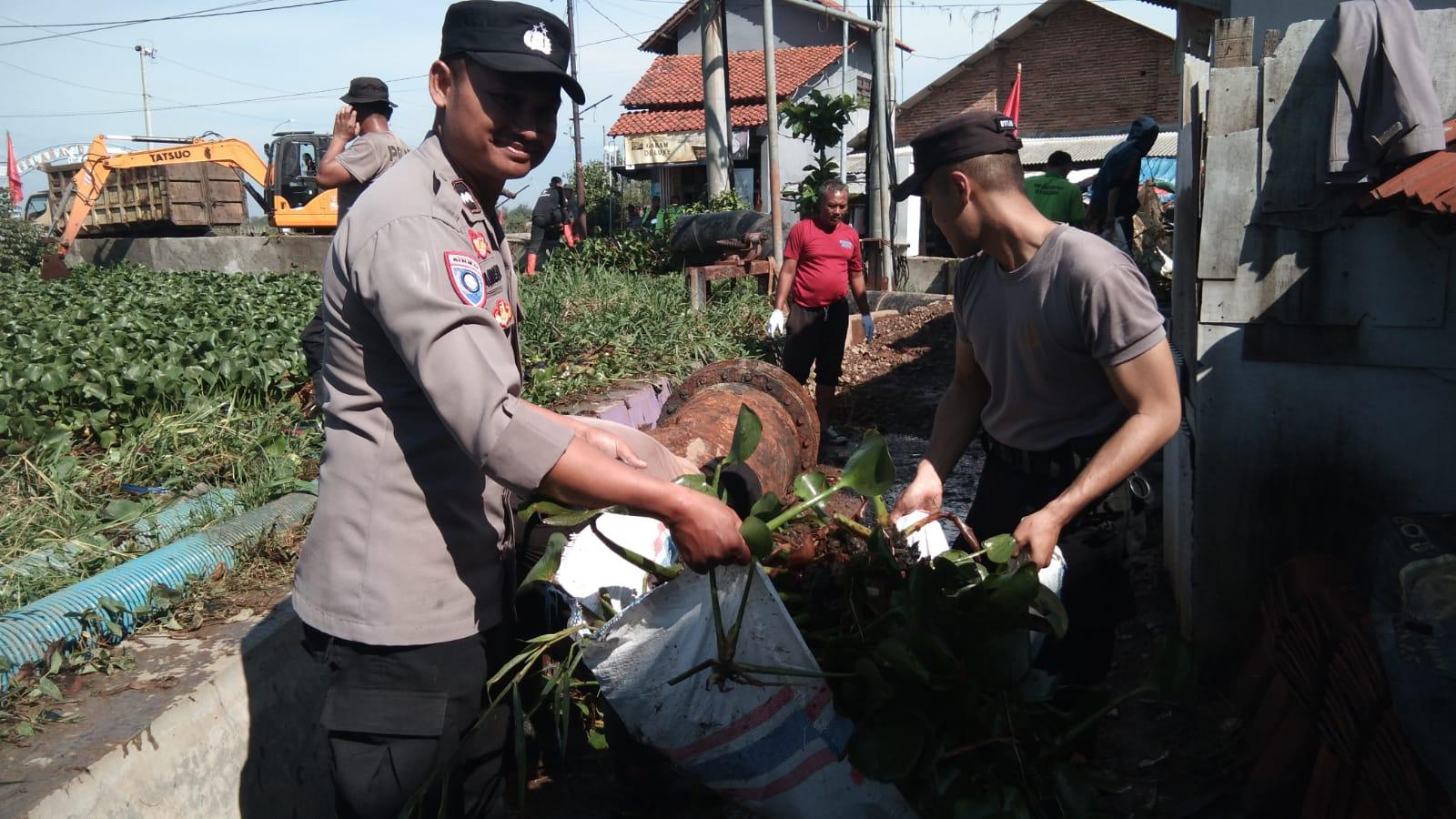 Personel gabungan Tiga Pilar Kota Pekalongan bersama warga dan instansi lain melaksanakan kerja bakti membersihkan lingkungan di sekitar sungai Bremi, (25/1).