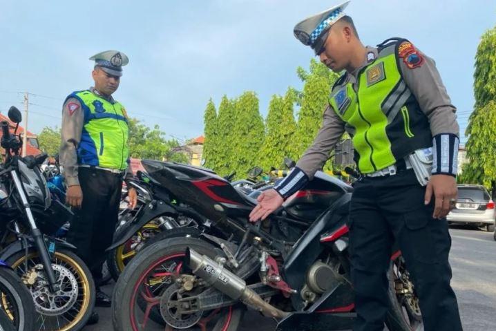 Polisi menunjukkan knalpot sepeda motor yang tidak standar.