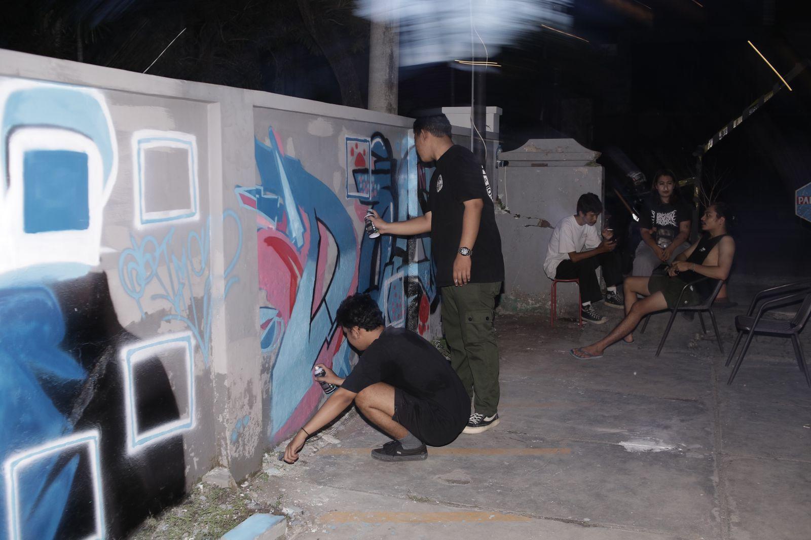 Dua pemuda nampak sedang menggambar gratifiti di dinding halaman cafe overline belum lama ini.