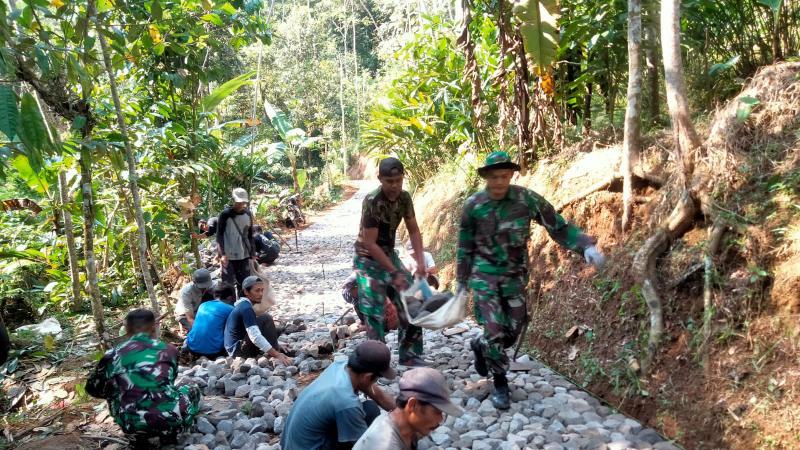 Pengerasan jalan 1100 meter di Desa Tempurejo oleh Kodim 0707Wonosobo melalui TMMD Sengkuyung Tahap III, melibatkan gotong royong TNI dan masyarakat, untuk meningkatkan akses ekonomi lokal. 30 7 2024