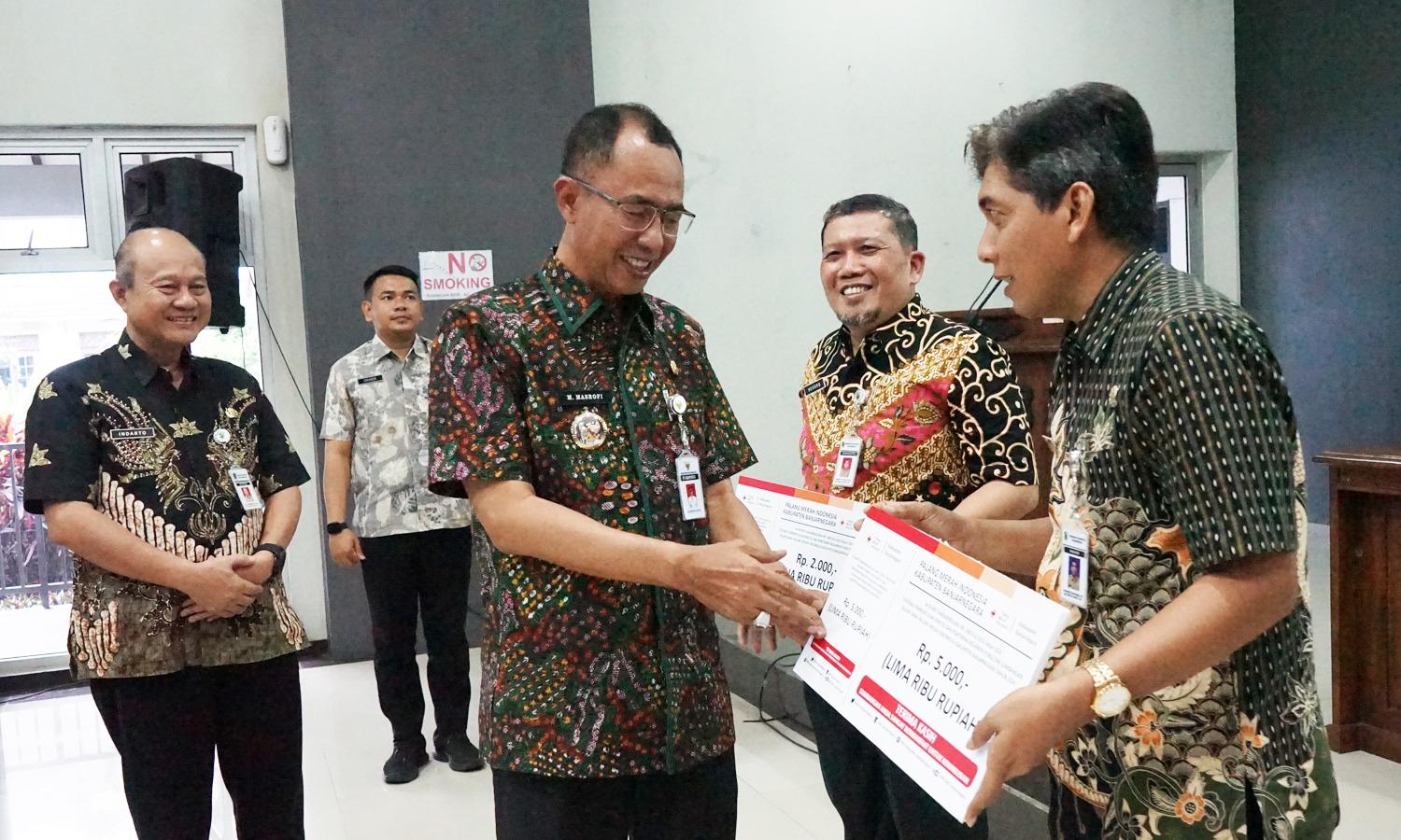 Pj Bupati Masrofi memberikan bantuan dana PMI sebesar 100 dollar untuk mengawali kegiatan bulan dana PMI 2024.(foto/ahr)