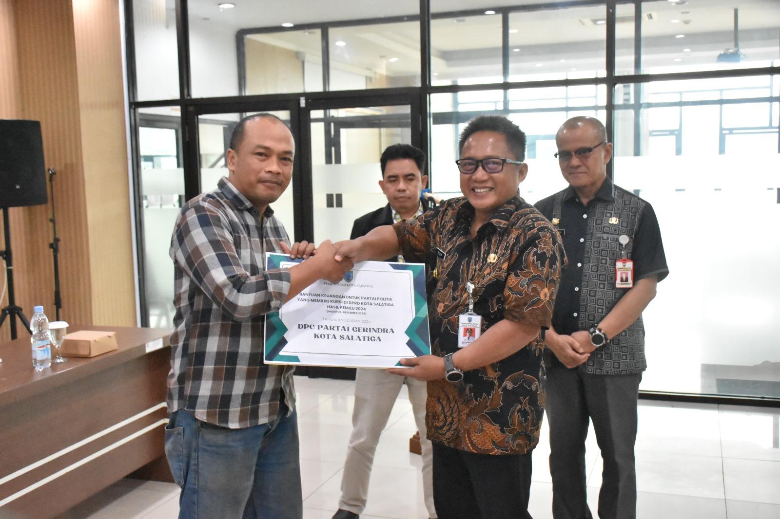 Penjabat (Pj) Wali Kota Salatiga Yasip Khasani (kanan) saat menyerahkan bantuan keuangan kepada parpol. (Dok.Pemkot Salatiga)