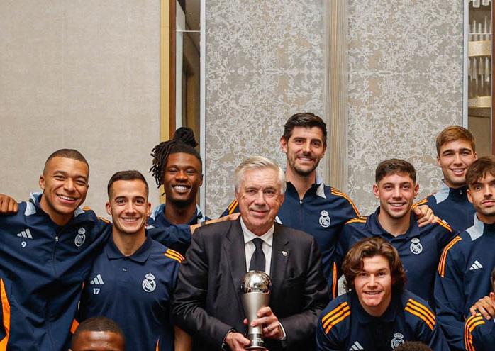 Pelatih Real Madrid Carlo Ancelotti mengangkat trofi bersama pemainnya usai dinobatkan sebagai pelatih terbaik FIFA 2024.(Twitter/@realmadrid)