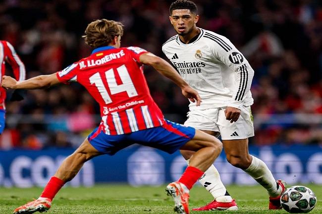 Pemain Real Madrid Jude Bellingham (kanan) saat mencoba melewati hadangan pemain Atletico Madrid dalam laga liga Champions. (Twitter/@realmadriden)